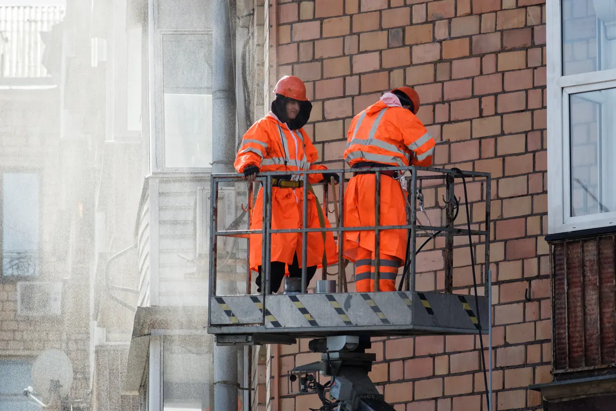 Crew pressure washing a building exterior